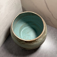 Interior view of handmade stoneware vessel revealing deep teal glazed surface with fired speckle detail